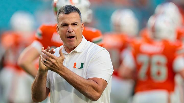 Oct 17, 2025; Miami Gardens, Florida, USA; Miami Hurricanes head coach Mario Cristobal works with his players before the game against the Louisville Cardinals at Hard Rock Stadium. Mandatory Credit: Sam Navarro-Imagn Images