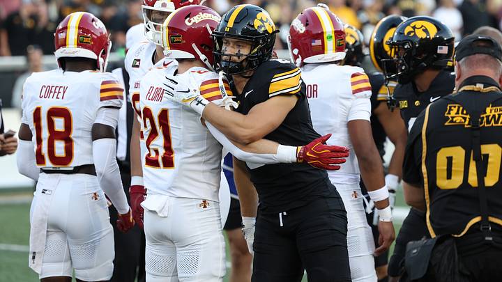 Sep 12, 2026; Iowa City, Iowa, USA;  Iowa State Cyclones running back Aiden Flora (21) and Iowa Hawkeyes defensive back Zach Lutmer (6) hug during the coin toss prior to a game at Kinnick Stadium.  Mandatory Credit: Reese Strickland-Imagn Images