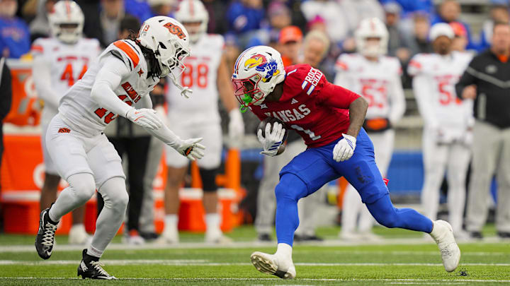 Nov 1, 2025; Lawrence, Kansas, USA; Kansas Jayhawks wide receiver Emmanuel Henderson Jr. (1) runs with the ball against Oklahoma State Cowboys cornerback Eric Fletcher (13).