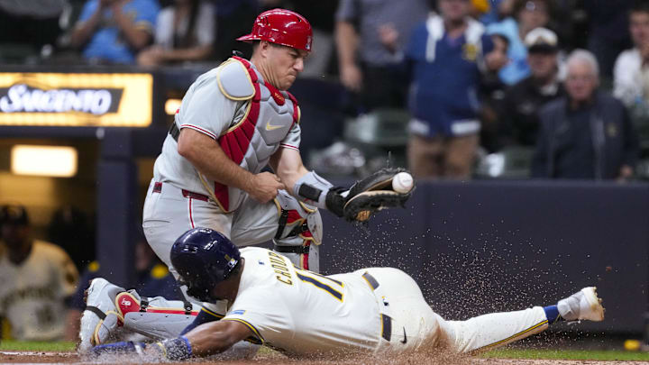 Milwaukee Brewers center fielder Jackson Chourio (11) slides into home plate to score a run before Philadelphia Phillies catcher J.T. Realmuto (10) can apply the tag during the first inning at American Family Field. 