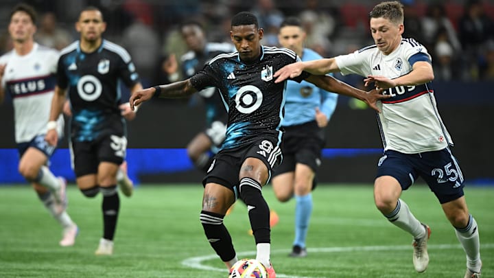Minnesota United midfielder Joseph Rosales (8) controls the ball against Vancouver Whitecaps FC midfielder Ryan Gauld (25)  