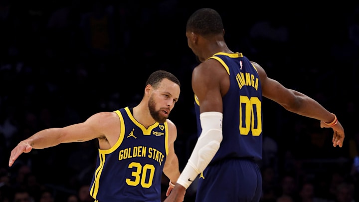 Mar 16, 2024; Los Angeles, California, USA; Golden State Warriors guard Stephen Curry (30) celebrates with forward Jonathan Kuminga (00) after a basket during the third quarter against the Los Angeles Lakers at Crypto.com Arena. Mandatory Credit: Jason Parkhurst-Imagn Images
