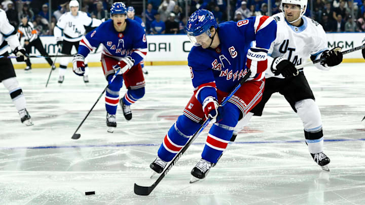 Oct 12, 2024; New York, New York, USA; New York Rangers defenseman Jacob Trouba (8) skates with the puck against Utah Hockey Club center Alex Kerfoot (15) during the third period at Madison Square Garden. Mandatory Credit: John Jones-Imagn Images