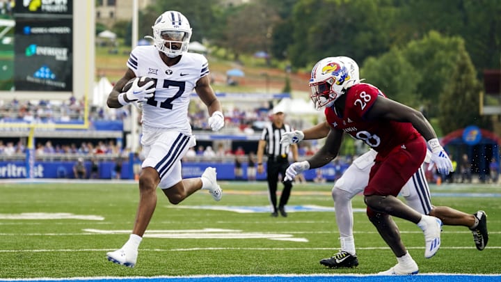 Sep 23, 2023; Lawrence, Kansas, USA; Brigham Young Cougars wide receiver Keelan Marion (17) scores a touchdown against Kansas Jayhawks linebacker JB Brown (28) during the second half at David Booth Kansas Memorial Stadium. Mandatory Credit: Jay Biggerstaff-USA TODAY Sports