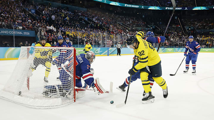 Feb 18, 2026; Milan, Italy; Connor Hellebuyck (37) of the United States makes a save against Gabriel Landeskog (92) of Sweden in a men's ice hockey quarterfinal during the Milano Cortina 2026 Olympic Winter Games at Milano Santagiulia Ice Hockey Arena. Mandatory Credit: Geoff Burke-Imagn Images