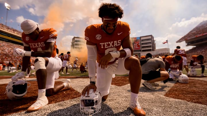 Texas Longhorn football players take a knee after taking the field for a football game against UTEP at Darrell K Royal–Texas Memorial Stadium in Austin, Texas, on Saturday, Sept. 13, 2025.