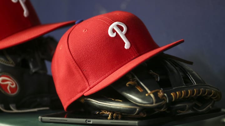May 25, 2022; Atlanta, Georgia, USA; Detailed view of a Philadelphia Phillies hat and glove in the dugout against the Atlanta Braves in the eighth inning at Truist Park. Mandatory Credit: Brett Davis-Imagn Images
