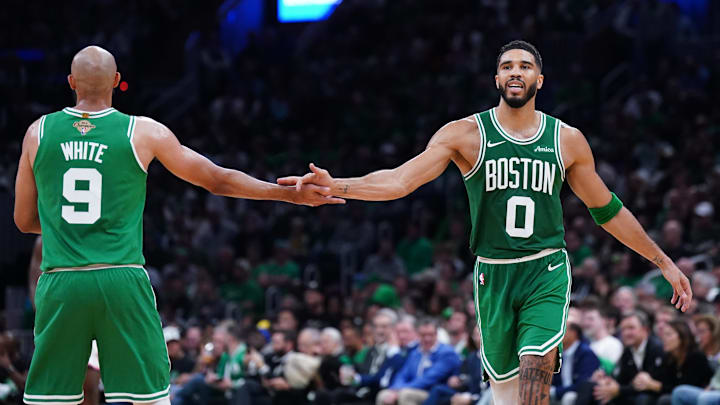 Boston Celtics forward Jayson Tatum (0) reacts with guard Derrick White.