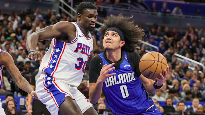 Jan 12, 2025; Orlando, Florida, USA; Orlando Magic guard Anthony Black (0) drives to the basket in front of Philadelphia 76ers center Adem Bona (30) during the second half at Kia Center. Mandatory Credit: Mike Watters-Imagn Images