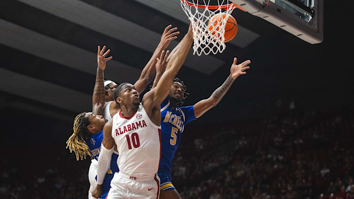Nov 11, 2024; Tuscaloosa, Alabama, USA; Alabama Crimson Tide forward Mouhamed Dioubate (10) and forward Jarin Stevenson (15) jump to recover a rebound against McNeese State Cowboys forward Joe Charles (5) and forward Christian Shumate (24) during the first half at Coleman Coliseum. Mandatory Credit: Will McLelland-Imagn Images