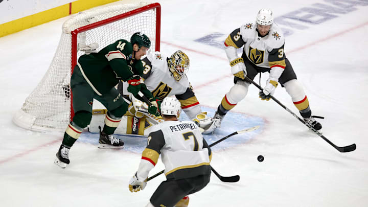Apr 26, 2025; Saint Paul, Minnesota, USA; Minnesota Wild center Joel Eriksson Ek (14) looks for a loose puck in front of Vegas Golden Knights goaltender Adin Hill (33) during 1st OT in game four of the first round of the 2025 Stanley Cup Playoffs at Xcel Energy Center. Mandatory Credit: Bruce Fedyck-Imagn Images