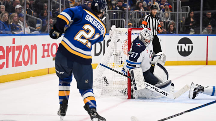 May 2, 2025; St. Louis, Missouri, USA; St. Louis Blues right wing Jimmy Snuggerud (21) is unable to score past Winnipeg Jets goaltender Connor Hellebuyck (37) during the second period in game six of the first round of the 2025 Stanley Cup Playoffs at Enterprise Center. Mandatory Credit: Connor Hamilton-Imagn Images