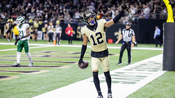 Dec 21, 2025; New Orleans, Louisiana, USA;  New Orleans Saints wide receiver Chris Olave (12) waves to fans after scoring a touchdown against New York Jets cornerback Brandon Stephens (21) during the second half  at Caesars Superdome. Mandatory Credit: Stephen Lew-Imagn Images