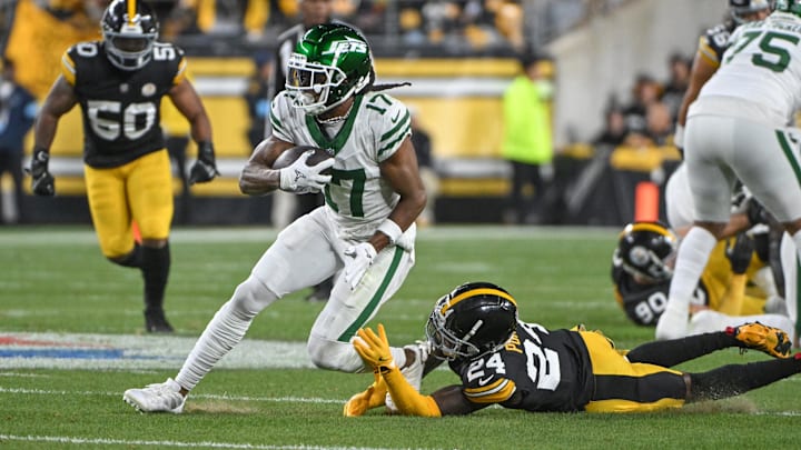 Oct 20, 2024; Pittsburgh, Pennsylvania, USA; NNew York Jets wide receiver Davante Adams (17) eludes Pittsburgh Steelers cornerback Joey Porter Jr. (24) on a pass during the first quarter at Acrisure Stadium.