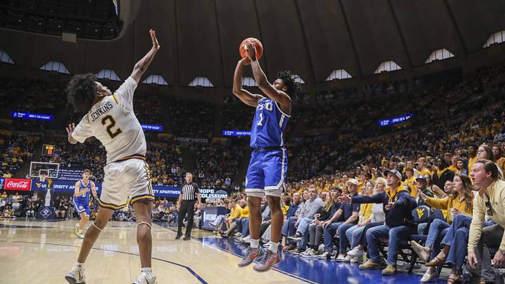 Feb 28, 2026; Morgantown, West Virginia, USA; BYU Cougars guard Robert Wright III (1) shoots a three point shot from the corner over West Virginia Mountaineers guard Amir Jenkins (2) during the first half at Hope Coliseum. Mandatory Credit: Ben Queen-Imagn Images