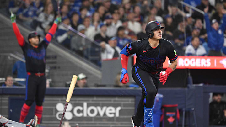 Toronto Blue Jays catcher Brandon Valenzuela (59) hits a two-run home run as designated hitter George Springer (4) reacts