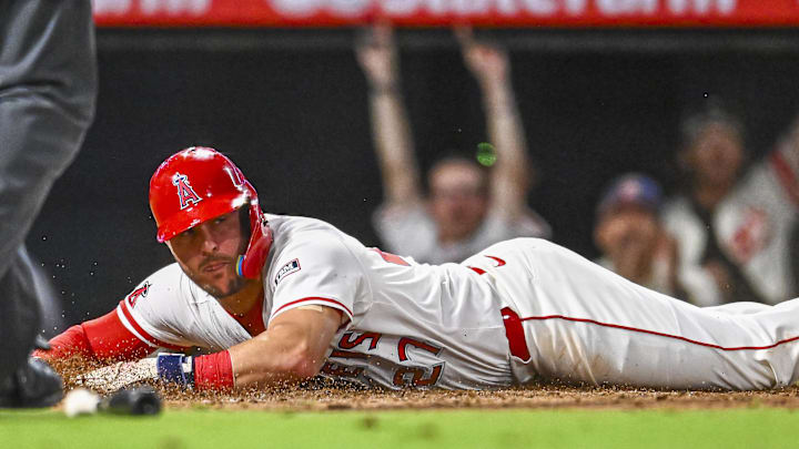 Sep 27, 2025; Anaheim, California, USA; Los Angeles Angels designated hitter Mike Trout (27) slides into home plate against Houston Astros catcher Yainer Diaz (21) during the sixth inning at Angel Stadium. Mandatory Credit: Jonathan Hui-Imagn Images