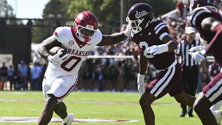 Oct 26, 2024; Starkville, Mississippi, USA;  Arkansas Razorbacks running back Braylen Russell (0) runs the ball while defended by Mississippi State Bulldogs safety Isaac Smith (2) during the first quarter at Davis Wade Stadium at Scott Field. Mandatory Credit: Matt Bush-Imagn Images