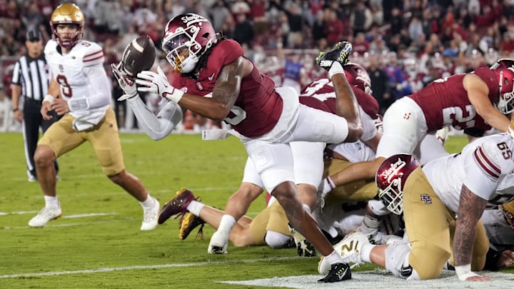 Sep 13, 2025; Stanford, California, USA; Stanford Cardinal safety Jay Green (center) reaches for a ball fumbled by Boston College Eagles running back Turbo Richard (not shown) during the third quarter at Stanford Stadium. Mandatory Credit: Darren Yamashita-Imagn Images