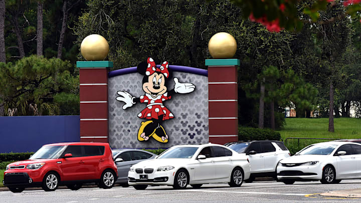 Cars drive past a sign featuring Minnie Mouse at the...