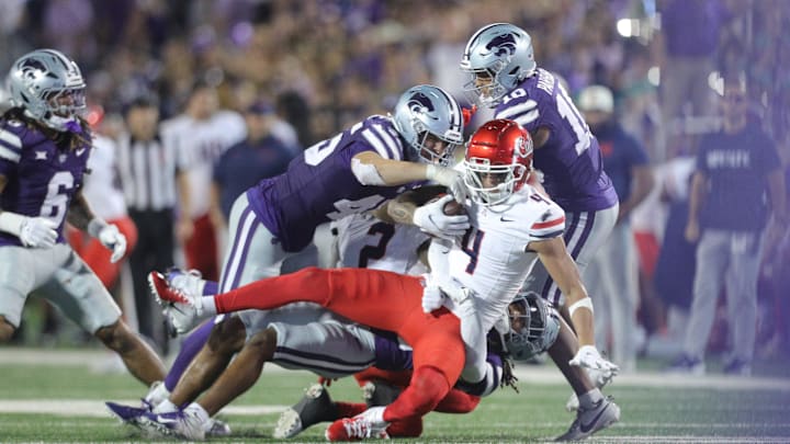 Arizona Wildcats wide receiver Tetairoa McMillan (4) is taken down by Kansas State players during the third quarter of the game at Bill Snyder Family Stadium on Friday, September 13, 2024. Arizona Wildcats wide receiver Tetairoa McMillan (4) is taken down by Kansas State players during the third quarter of the game at Bill Snyder Family Stadium on Friday, September 13, 2024.