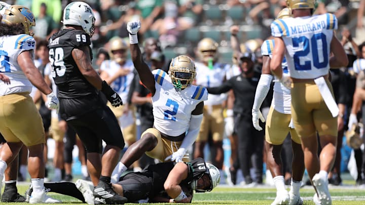 Aug 31, 2024; Honolulu, Hawaii, USA;  UCLA Bruins linebacker Oluwafemi Oladejo (2) reacts after tackling Hawaii Rainbow Warriors quarterback Brayden Schager (13) during the second quarter of an NCAA college football game at the Clarence T.C. Ching Athletics Complex. Mandatory Credit: Marco Garcia-Imagn Images