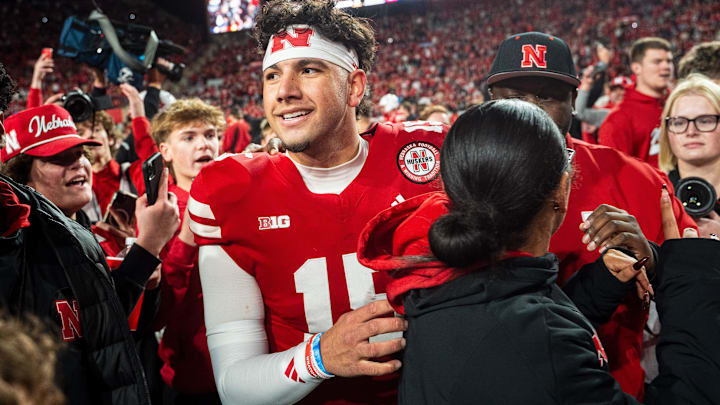 Nebraska Cornhuskers quarterback Dylan Raiola (15) walks off as fans rush the field