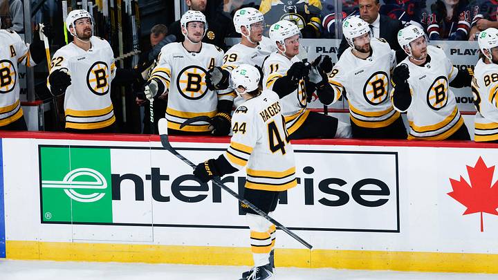 Oct 2, 2026; Winnipeg, Manitoba, CAN;  Boston Bruins forward James Hagens (44) is congratulated by his team mates on his goal against Winnipeg Jets goalie Stuart Skinner (74) during the first period at Canada Life Centre.  Mandatory Credit: Terrence Lee-Imagn Images