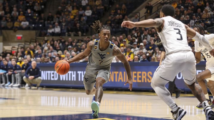 Mar 8, 2025; Morgantown, West Virginia, USA; West Virginia Mountaineers guard Javon Small (7) drives down the lane against UCF Knights guard Darius Johnson (3) during the first half at WVU Coliseum. Mandatory Credit: Ben Queen-Imagn Images