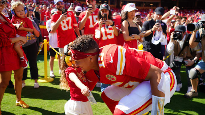 Sep 28, 2025; Kansas City, Missouri, USA; Kansas City Chiefs quarterback Patrick Mahomes (15) hugs his daughter before the game against the Baltimore Ravens at GEHA Field at Arrowhead Stadium. Mandatory Credit: Denny Medley-Imagn Images