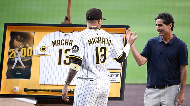Jul 8, 2025; San Diego, California, USA; San Diego Padres third baseman Manny Machado (13) shakes hands with general manager A.J. Preller after receiving commemorative memorabilia recognizing his 2,000th hit before a baseball game against the Arizona Diamondbacks at Petco Park. Mandatory Credit: Denis Poroy-Imagn Images