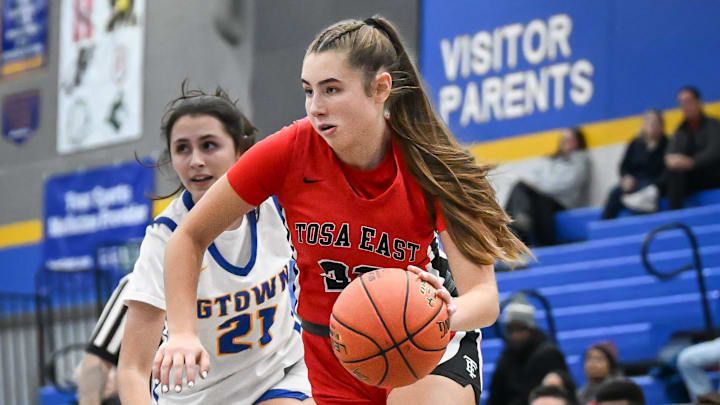 Wauwatosa East forward Ellie Deprey (22) drives past Germantown guard Mae Reese (21) in a Greater Metro Conference game Friday, December 5, 2025.