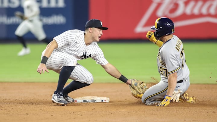 Sep 8, 2023; Bronx, New York, USA;  New York Yankees shortstop Anthony Volpe (11) tries to tag Milwaukee Brewers shortstop Willy Adames (27) at second base in the seventh inning at Yankee Stadium. Mandatory Credit: Wendell Cruz-Imagn Images
