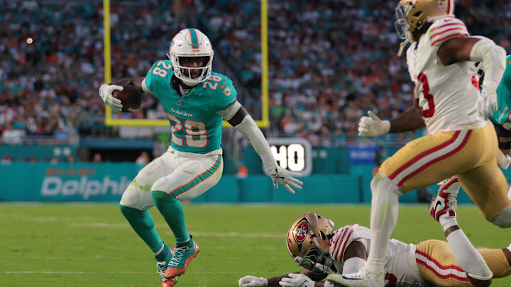 Dec 22, 2024; Miami Gardens, Florida, USA; Miami Dolphins running back De'Von Achane (28) runs with the football past San Francisco 49ers linebacker Demetrius Flannigan-Fowles (45) during the second quarter at Hard Rock Stadium. Mandatory Credit: Sam Navarro-Imagn Images