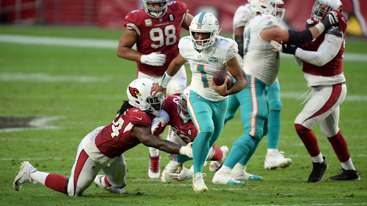Miami Dolphins quarterback Tua Tagovailoa (1) breaks the tackle of Arizona Cardinals linebacker Markus Golden (44) and Arizona Cardinals cornerback Byron Murphy (33) during the second half at State Farm Stadium in 2020. Miami Dolphins quarterback Tua Tagovailoa (1) breaks the tackle of Arizona Cardinals linebacker Markus Golden (44) and Arizona Cardinals cornerback Byron Murphy (33) during the second half at State Farm Stadium in 2020.
