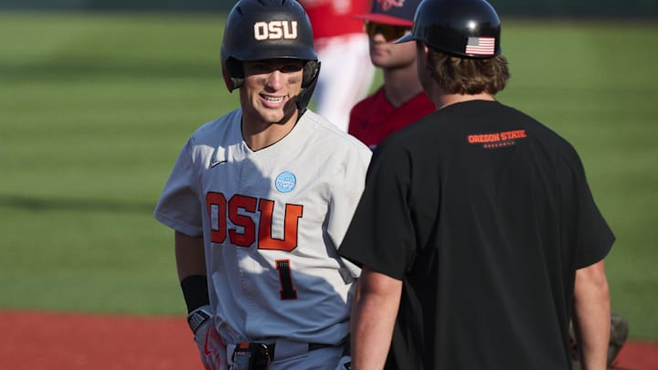 Jun 1, 2025; Corvallis, OR, USA; Oregon St. outfielder Gavin Turley (1) smiles with a first base coach after hitting an RBI single in the ninth inning against Saint Mary's at the NCAA Corvallis Regional at Goss Stadium. Turley broke the team record for RBI’s on the play. Mandatory Credit: Troy Wayrynen-Imagn Images