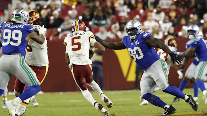 Nov 2, 2025; Landover, Maryland, USA; Washington Commanders quarterback Jayden Daniels (5) scrambles from Seattle Seahawks defensive tackle Jarran Reed (90) during the third quarter at Northwest Stadium. 