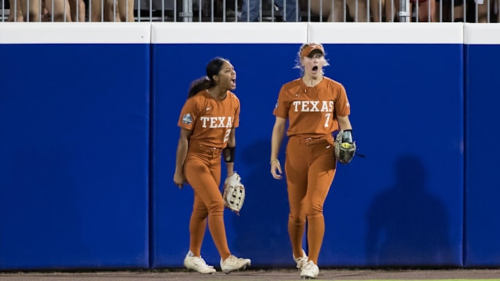 Jun 5, 2024; Oklahoma City, OK, USA;  Texas Longhorns outfielder Ashton Maloney (7) reacts after catching a ball at the wall for an out as Texas Longhorns outfielder Kayden Henry (21) looks on in the seventh inning against the Oklahoma Sooners during game one of the Women's College World Series softball championship finals at Devon Park. Mandatory Credit: Brett Rojo-Imagn Images