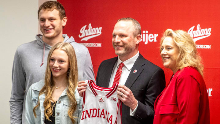 Indiana University men's basketball Head Coach Darian DeVries poses with his family, his son Tucker DeVries, left, his wife Ashley DeVries, right, and his daughter Tatum DeVries, front, at the introductory press conference at Simon Skjodt Assembly Hall on Wednesday, March 19, 2025.