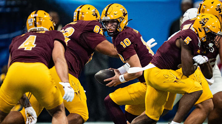 Arizona State Sun Devils quarterback Sam Leavitt (10) looks to hand the ball of to running back Cam Skattebo (4) in the first quarter as the Texas Longhorns play the Arizona State Sun Devils in the Peach Bowl College Football Playoff quarterfinal at Mercedes-Benz Stadium in Atlanta, Georgia, Jan. 1, 2025.