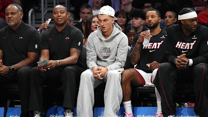Oct 8, 2025; Miami, Florida, USA;  Miami Heat guard Tyler Herro, center, watches the game against the San Antonio Spurs from the bench at Kaseya Center as he recovers from an injury. Mandatory Credit: Jim Rassol-Imagn Images