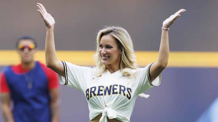 Paige Spiranac waves to the crowd after throwing out a first pitch prior to the game between the Pittsburgh Pirates and Milwaukee Brewers at American Family Field.