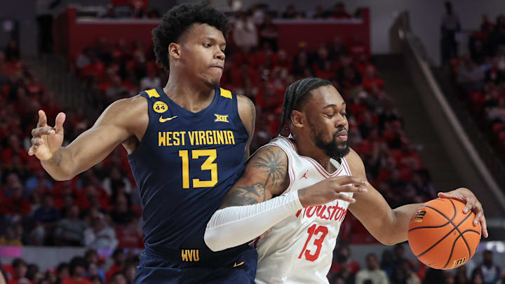 Jan 15, 2025; Houston, Texas, USA; Houston Cougars forward J'Wan Roberts (13) dribbles against West Virginia Mountaineers forward Amani Hansberry (13) in the first half at Fertitta Center. Mandatory Credit: Thomas Shea-Imagn Images