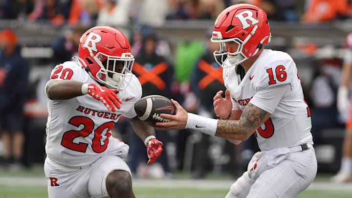 Nov 1, 2025; Champaign, Illinois, USA;  Rutgers Scarlet Knights quarterback Athan Kaliakmanis (16) hands the ball to  running back Ja'shon Benjamin (20) during the second half against the Illinois Fighting Illini  at Memorial Stadium.  Credit: Ron Johnson-Imagn Images