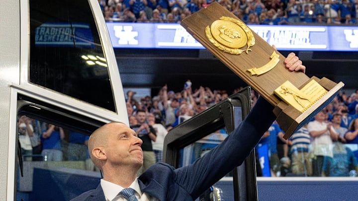 Mark Pope exits the bus with holding a trophy as he enters Rupp Arena greeting thousands of fans for his introductory press conference on Sunday, April 14, 2024.