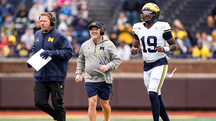 Michigan offensive coordinator Jason Beck, head coach Kyle Whittingham, and quarterback Bryce Underwood run across the field during the spring game