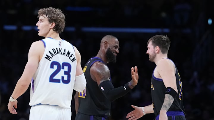 Nov 18, 2025; Los Angeles, California, USA; Los Angeles Lakers forward LeBron James (center) and guard Luka Doncic (77) react as Utah Jazz forward Lauri Markkanen (23) watches in the fourth quarter at Crypto.com Arena. Mandatory Credit: Kirby Lee-Imagn Images
