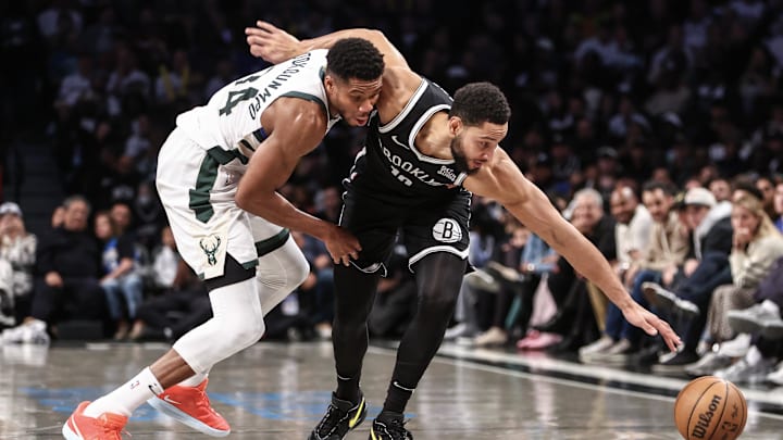 Oct 27, 2024; Brooklyn, New York, USA;  Milwaukee Bucks forward Giannis Antetokounmpo (34) and Brooklyn Nets guard Ben Simmons (10) fight for a loose ball in the fourth quarter at Barclays Center. Mandatory Credit: Wendell Cruz-Imagn Images