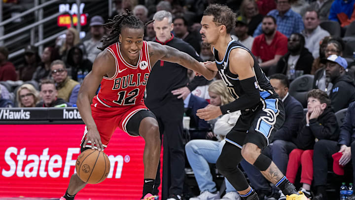 Feb 12, 2024; Atlanta, Georgia, USA; Chicago Bulls guard Ayo Dosunmu (12) dribbles against Atlanta Hawks guard Trae Young (11) during the second half at State Farm Arena. Mandatory Credit: Dale Zanine-Imagn Images