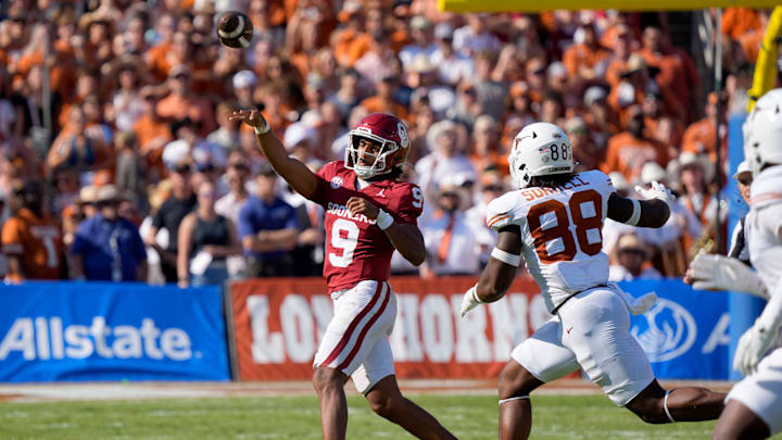 Oklahoma Sooners quarterback Michael Hawkins Jr. throws a pass as Texas Longhorns linebacker Barryn Sorrell chases after him during the Red River Rivalry.
